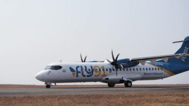 Aerial view of an airplane soaring above vibrant Indian cities, symbolizing FLY91's regional air travel services. | FLY91 Launch | India Connectivity