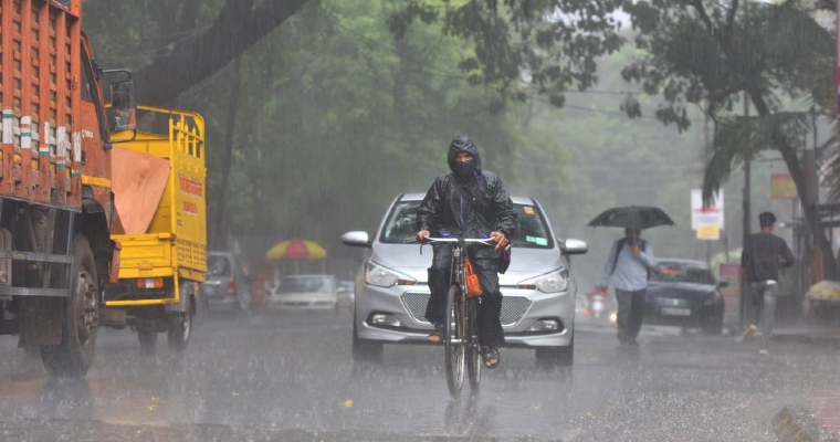 A cityscape of Nagpur under cloudy skies with rain and thunderstorms looming.