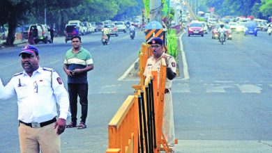 A busy traffic intersection on Wardha Road, showing restricted right turns with a traffic officer managing the flow.