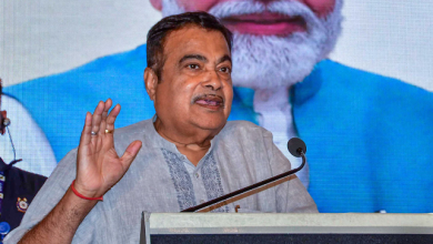 Nitin Gadkari addressing a press conference, surrounded by supporters and banners displaying his manifesto goals