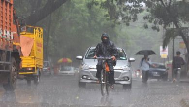 A cityscape of Nagpur under cloudy skies with rain and thunderstorms looming.