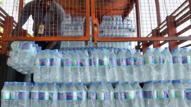 Railway inspection team confiscating unauthorized water bottles at a railway station.