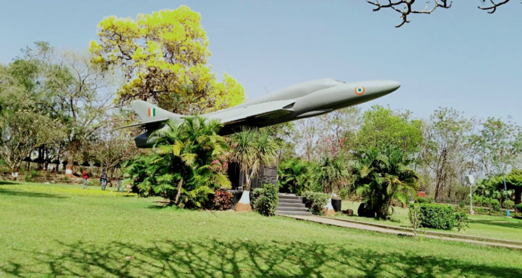 Volunteers maintaining Nagpur parks and gardens with tools and greenery in the background.