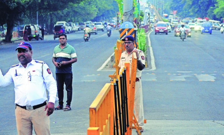 A busy traffic intersection on Wardha Road, showing restricted right turns with a traffic officer managing the flow.