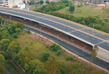 Damaged Butibori flyover under repair with green nets and support structures installed.