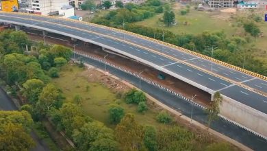 Damaged Butibori flyover under repair with green nets and support structures installed.