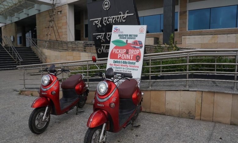 Commuter using a Switch E-Ride e-scooter near a MahaMetro station.