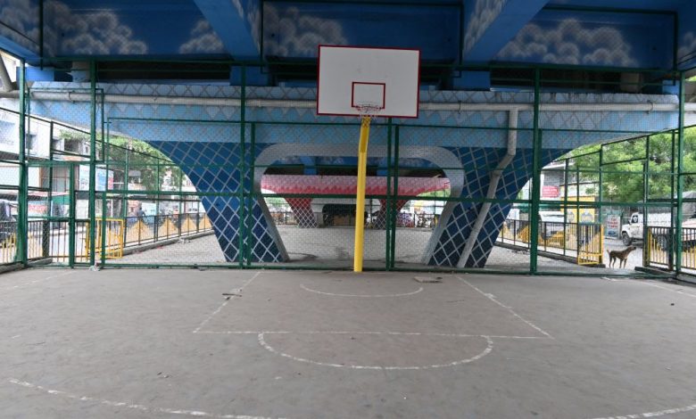 Transformed flyover space in Nagpur featuring a basketball court, green seating areas, and a public gym setup